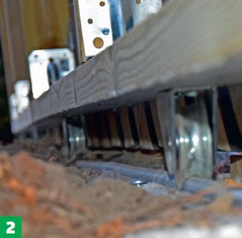 Skydeport: Porten sættes på bundskinnen. Skydeport: Porten sættes på bundskinnen.